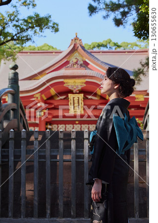 朱塗りの拝殿を背景にポーズをとる振袖姿の女性|神社・着物・伝統美 朱塗りの拝殿を背景にポーズをとる振袖姿の女性|神社・着物・伝統美 130655630