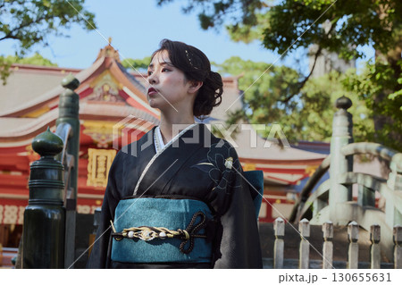朱塗りの拝殿を背景にポーズをとる振袖姿の女性|神社・着物・伝統美 朱塗りの拝殿を背景にポーズをとる振袖姿の女性|神社・着物・伝統美 130655631