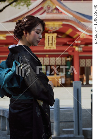 朱塗りの拝殿を背景にポーズをとる振袖姿の女性|神社・着物・伝統美 朱塗りの拝殿を背景にポーズをとる振袖姿の女性|神社・着物・伝統美 130655640