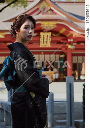 朱塗りの拝殿を背景にポーズをとる振袖姿の女性|神社・着物・伝統美 朱塗りの拝殿を背景にポーズをとる振袖姿の女性|神社・着物・伝統美 130655641