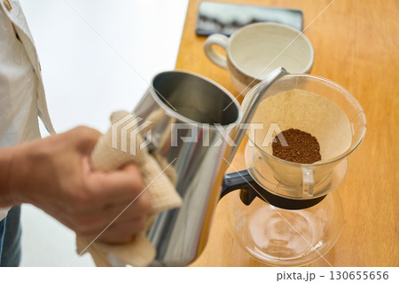 1回目の蒸らしの湯を注ぐ男性。ペーパードリップでコーヒーを淹れる工程の連続写真。 1回目の蒸らしの湯を注ぐ男性。ペーパードリップでコーヒーを淹れる工程の連続写真。 130655656