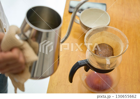 1回目の蒸らしの湯を注ぐ男性。ペーパードリップでコーヒーを淹れる工程の連続写真。 1回目の蒸らしの湯を注ぐ男性。ペーパードリップでコーヒーを淹れる工程の連続写真。 130655662