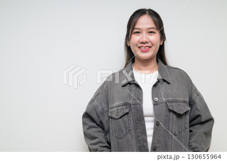 Portrait of young stylish happy Asian woman smiling against white background Portrait of young stylish happy Asian woman smiling against white background 130655964