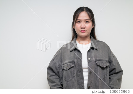 Portrait of young stylish Asian woman against white background 130655966