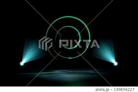 A glowing green neon spiral hovers over a dark stage, illuminated by two teal spotlights casting volumetric light beams and reflections on the floor. Abstract, futuristic digital concept. 130656227