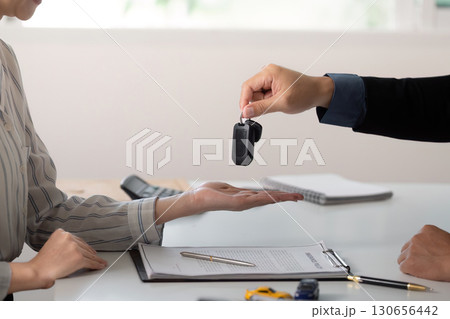 Car Dealership. Handing over car keys to a customer during a vehicle purchase. 130656442