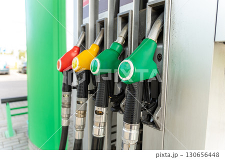 Close-up of four fuel dispensing nozzles on a gas pump 130656448
