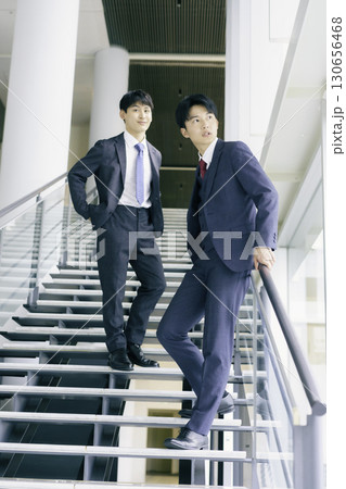 オフィスビルの階段に立つ若いビジネスマン2人のポートレート 縦位置 オフィスビルの階段に立つ若いビジネスマン2人のポートレート 縦位置 130656468