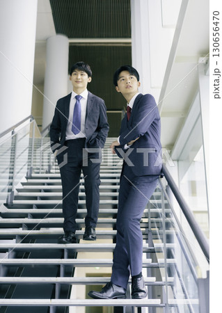オフィスビルの階段に立つ若いビジネスマン2人のポートレート　縦位置 130656470