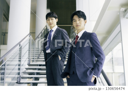 オフィスビルの階段に立つ若いビジネスマンのポートレート オフィスビルの階段に立つ若いビジネスマンのポートレート 130656474