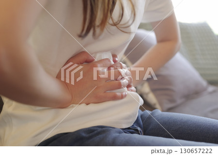 お腹を押さえる女性の腹痛イメージ お腹を押さえる女性の腹痛イメージ 130657222