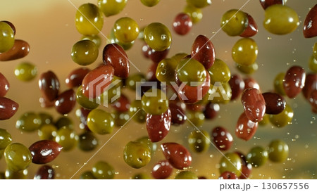 Freeze motion of flying fresh olives, isolated on gradient background. 130657556