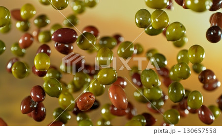 Freeze motion of flying fresh olives, isolated on gradient background. Freeze motion of flying fresh olives, isolated on gradient background. 130657558