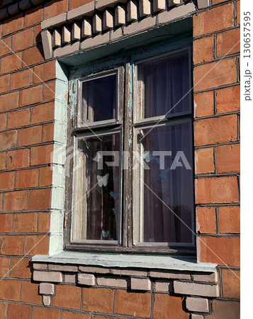 Window in a brick house. Dilapidated window frame. 130657595