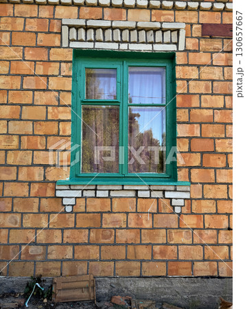 Window in a brick house. Wooden window frame painted green. 130657667
