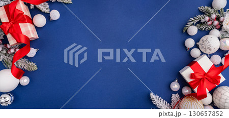 White Christmas Gift with Red Ribbon and Ornaments on Blue 130657852