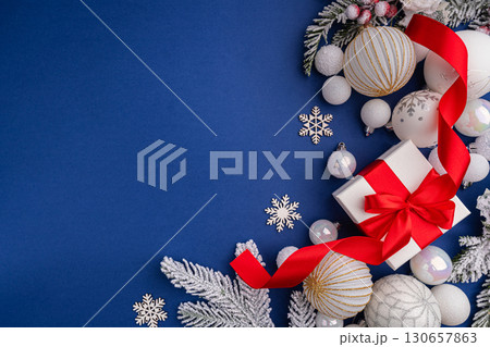 White Christmas Gift with Red Ribbon and Ornaments on Blue 130657863