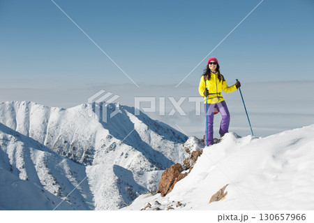Woman Standing on Top of Snowy Mountain 130657966