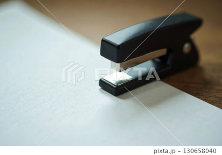 Stapler on white paper, workplace in office, student desk. AI Generative 130658040