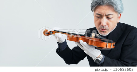 バイオリンを確認するミドルエイジ男性 130658608