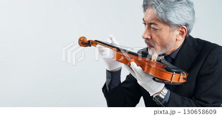 バイオリンを確認するミドルエイジ男性 130658609