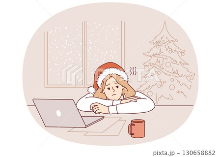 Christmas depression in woman forced to work on new year eve, sitting at table with laptop 130658882