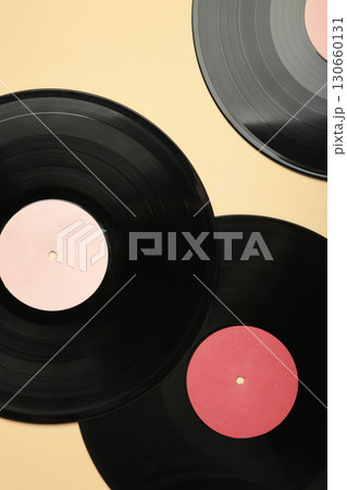 Vinyl record on beige background. Vertical photo 130660131