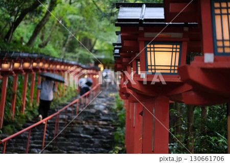 雨の中で参道を照らす神社の赤い灯籠と石段 130661706