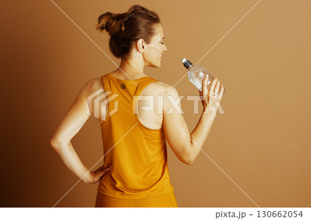 Smiling Woman Hydrating After Workout 130662054