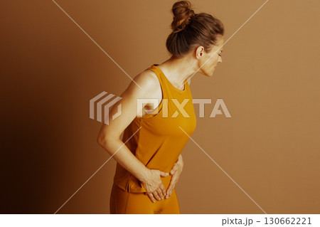 Woman with Abdominal Pain in Yellow Activewear Woman with Abdominal Pain in Yellow Activewear 130662221