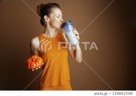 Smiling Woman with Seasonal Wellness Drink 130662500