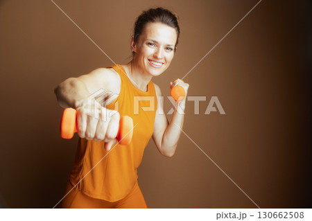 Energetic Woman with Dumbbells in Dynamic Pose 130662508