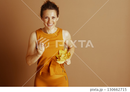 Joyful Fall Fitness: Woman with Autumn Leaves Joyful Fall Fitness: Woman with Autumn Leaves 130662715