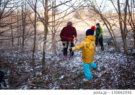 Winter adventure in the woods with joyful children exploring nature on a chilly day, filled with laughter and discovery while gathering treasures 130662936