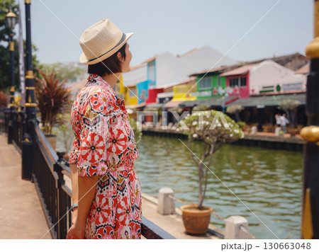 woman in dress and hat exploring vibrant streets of Malacca, Malaysia. woman in dress and hat exploring vibrant streets of Malacca, Malaysia. 130663048
