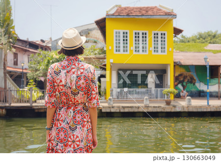 woman in dress and hat exploring vibrant streets of Malacca, Malaysia. woman in dress and hat exploring vibrant streets of Malacca, Malaysia. 130663049