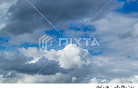 A beautiful white cumulus cloud is illuminated by the sun 130663415