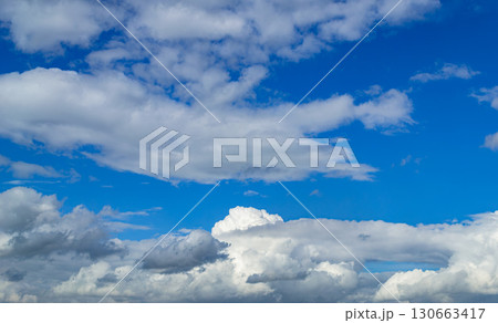 A beautiful white cumulus cloud is illuminated by the sun 130663417