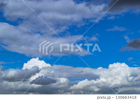 A beautiful white cumulus cloud is illuminated by the sun 130663418