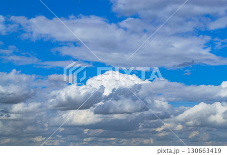 A beautiful white cumulus cloud is illuminated by the sun 130663419