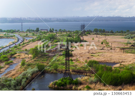 Heavy rain over the city and factories behind power lines in the field Heavy rain over the city and factories behind power lines in the field 130663453