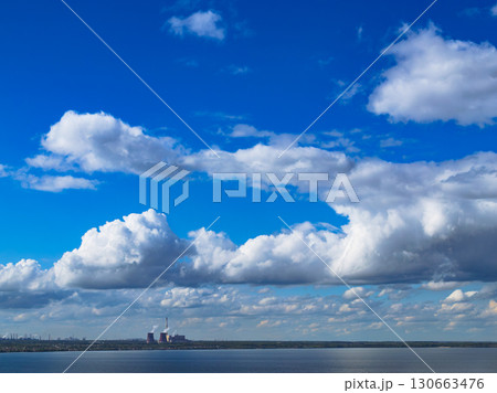 Industrial power plant by lake under blue sky 130663476