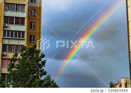 Rainbow between apartment buildings in city 130663494