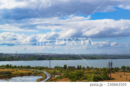 Scenic lake view with road and city skyline Scenic lake view with road and city skyline 130663505