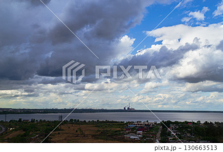 Storm clouds over lake and industrial skyline Storm clouds over lake and industrial skyline 130663513