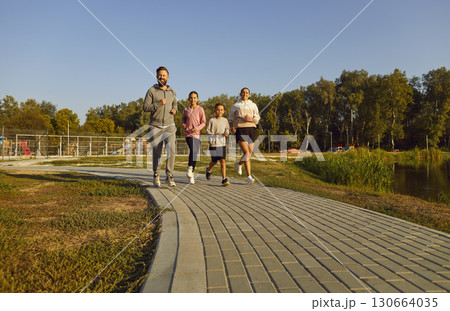 Team of young family with kids running together in the park having sport workout outdoors. 130664035