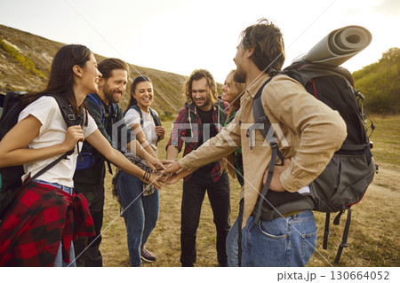 Team of happy friends huddling and having fun on their hiking or trekking holiday Team of happy friends huddling and having fun on their hiking or trekking holiday 130664052