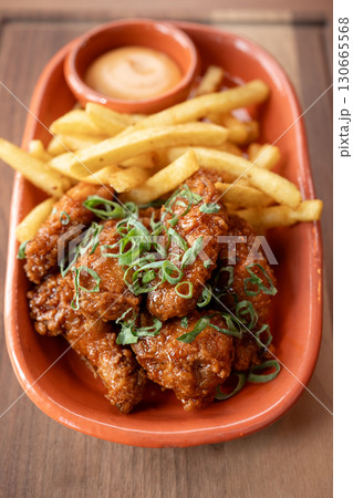 Crispy fried chicken wings served with golden fries and dipping sauce 130665568