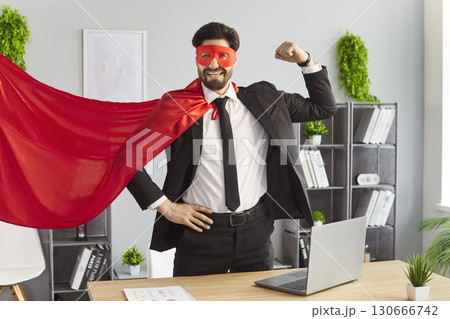 Happy brave businessman superhero with red cloak and mask, suit and gesture of power and strength 130666742