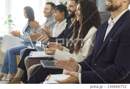 Business audience sitting in row in conference room and applauding, listening presentation 130666752